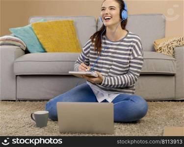 Beautiful woman at home studying while listen music