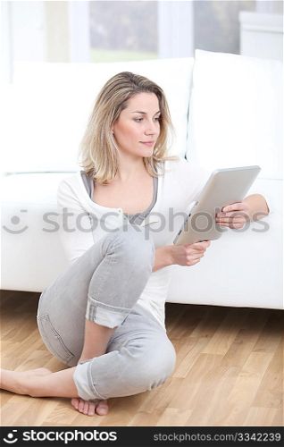 Beautiful woman at home using electronic tab