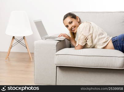 Beautiful woman at home working on her laptop