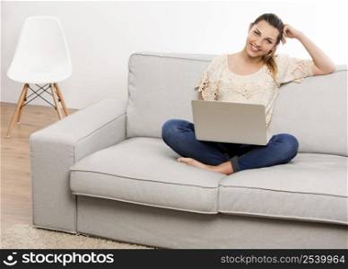 Beautiful woman at home working on her laptop