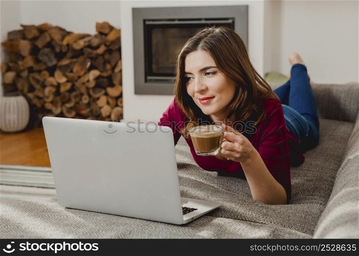 Beautiful woman at home working while drinking one capuchino