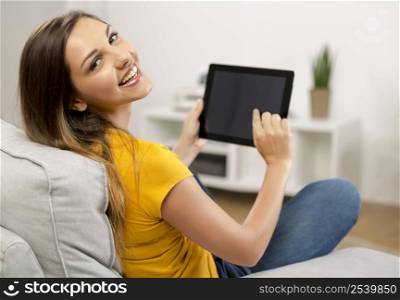 Beautiful woman at home working with a tablet