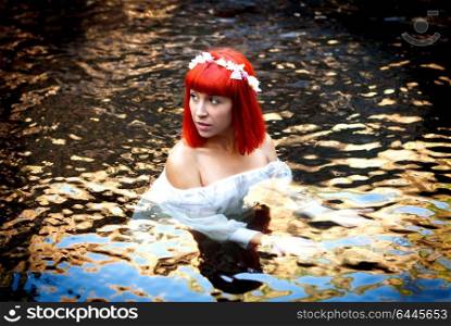 Beautiful woman bathing in a beautiful river dressed in white