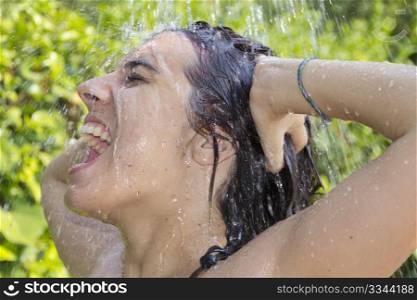 beautiful woman bathing under the water of a shower