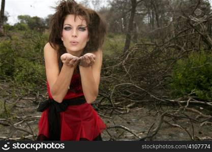 Beautiful woman, black magic on burned forest, red haute couture dress, witch and ashes