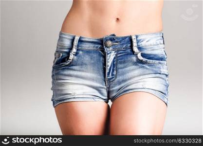 Beautiful woman body in denim jeans shorts on white background