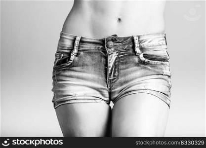 Beautiful woman body in denim jeans shorts on white background
