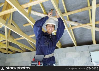 beautiful woman builder hammering the ceiling