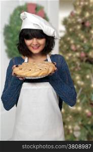 Beautiful woman chef holding a freshly baked pie