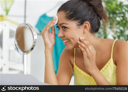 beautiful woman cleaning make up with cotton pad