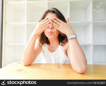 Beautiful woman closed her eyes against white background and the wood table.. Beautiful woman closed her eyes against white background