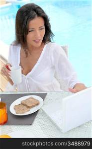 Beautiful woman connected on internet while having breakfast