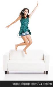 Beautiful woman dancing and jumping over the sofa, isolated in white