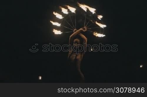 Beautiful woman doing fire show at the beach at night - video in slow motion
