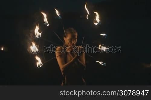 Beautiful woman doing fire show at the beach at night - video in slow motion
