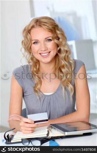 Beautiful woman doing online shopping in office