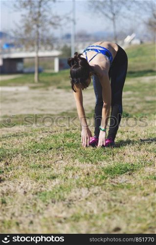 Beautiful woman doing stretching exercises in the park