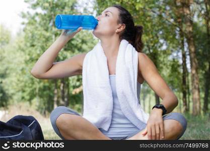 beautiful woman drinking water sitting in the park