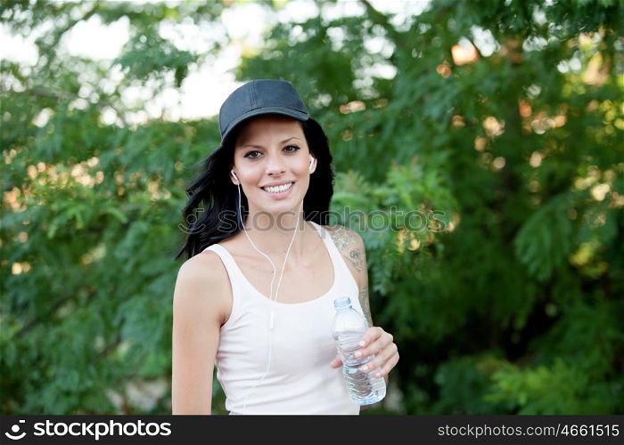 Beautiful woman drinking water while hiking through the countryside