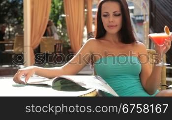 beautiful woman enjoying a cocktail in the open-air restaurant