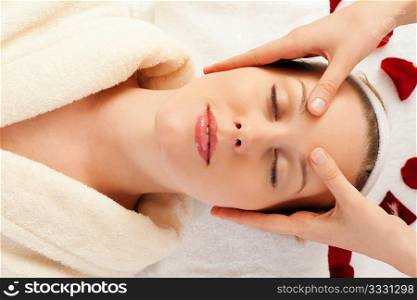 Beautiful woman enjoying a face massage competently carried out in a spa