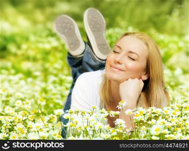 Beautiful woman enjoying daisy field, nice female lying down in the meadow of flowers, pretty girl relaxing outdoor, having fun, happy young lady and spring green nature, harmony and freedom concept