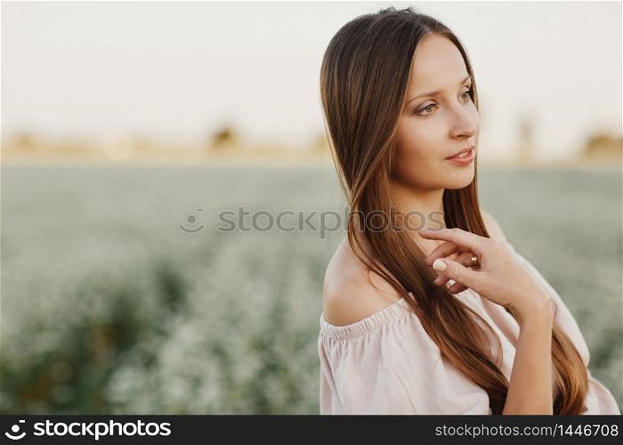 Beautiful woman enjoying field, happy young lady and spring green nature, harmony concept. portrait of a beautiful girl in a field of flowers. selective focus.. Beautiful woman enjoying field, happy young lady and spring green nature, harmony concept. portrait of a beautiful girl in a field of flowers. selective focus