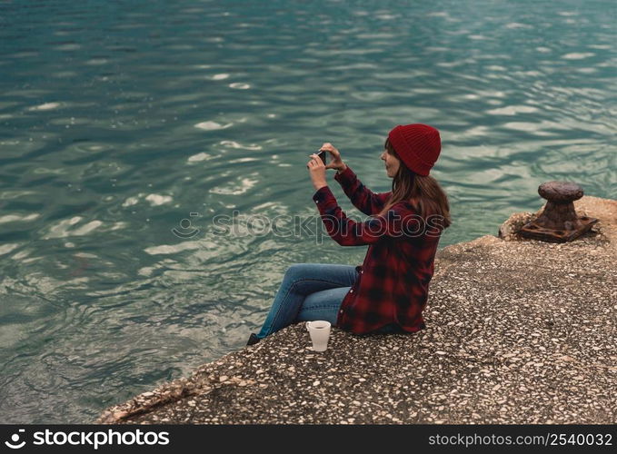 Beautiful woman enjoying her day taking pictures with her phone