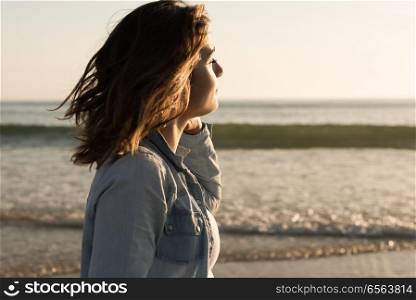 Beautiful woman enjoying sunset at the beach