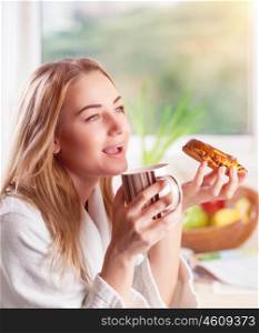 Beautiful woman enjoying tasty morning meal, drinking tea with sweet delicious bun, having breakfast in the hotel&#xA;