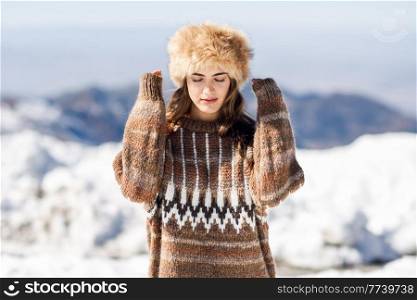 Beautiful woman enjoying the snowy mountains in winter, in Sierra Nevada, Granada, Spain. Female wearing winter clothes.. Young woman enjoying the snowy mountains in winter