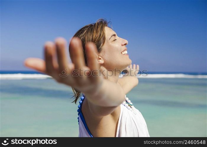 Beautiful woman enjoying the summer with both arms open