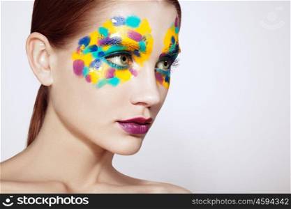 Beautiful woman face. Beauty girl face with colorful makeup. Beauty fashion. Eyelashes. Red lipstick. Cosmetic Eyeshadow. Make-up detail. Rainbow Colors