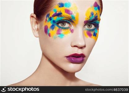 Beautiful woman face. Beauty girl face with colorful makeup. Beauty fashion. Eyelashes. Red lipstick. Cosmetic Eyeshadow. Make-up detail. Rainbow Colors