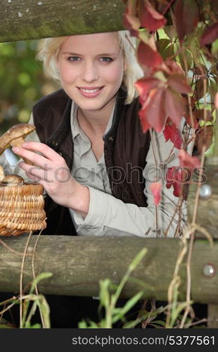 beautiful woman gathering mushrooms in the park