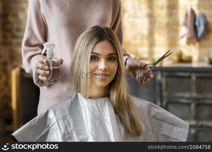 beautiful woman getting her hair cut home by hairdresser