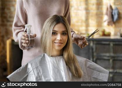 beautiful woman getting her hair cut home by hairdresser