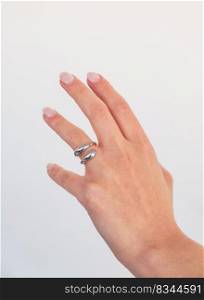 Beautiful woman hand with Bold Adjustable Silver Ring set against a white background. Romantic composition. Beautiful valentine&rsquo;s gift.
