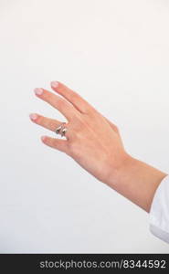 Beautiful woman hand with Bold Adjustable Silver Ring set against a white background. Romantic composition. Beautiful valentine’s gift.