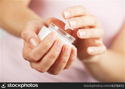 beautiful woman hands applying cream