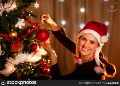 Beautiful woman hanging toy on Christmas tree&#xA;