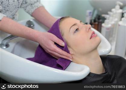 beautiful woman has her hair washed in salon
