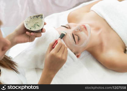 Beautiful woman having a facial cosmetic scrub treatment from professional dermatologist at wellness spa. Anti-aging, facial skin care and luxury lifestyle concept.. Beautiful woman having a facial treatment at spa.