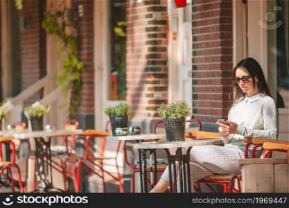 Beautiful woman having breakfast at outdoor cafe. Woman having breakfastin outdoor restaraunt