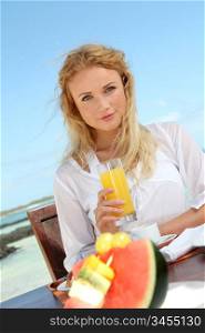 Beautiful woman having breakfast by the sea