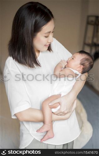 Beautiful woman holding a newborn baby in her arms