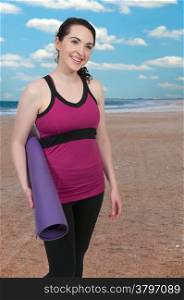 Beautiful woman holding a yoga mat before exercising