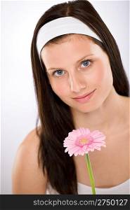 Beautiful woman holding gerbera daisy flower with white headband