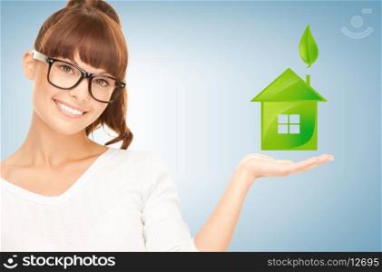 beautiful woman holding green house in her hands