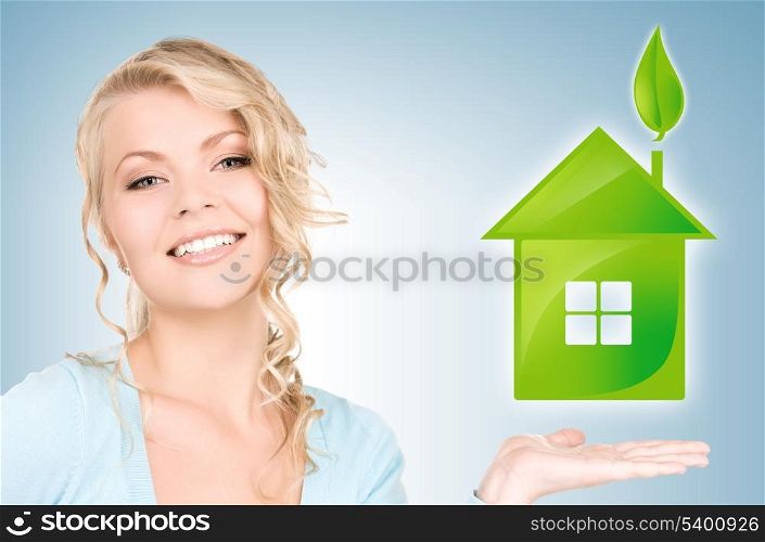 beautiful woman holding green house in her hands